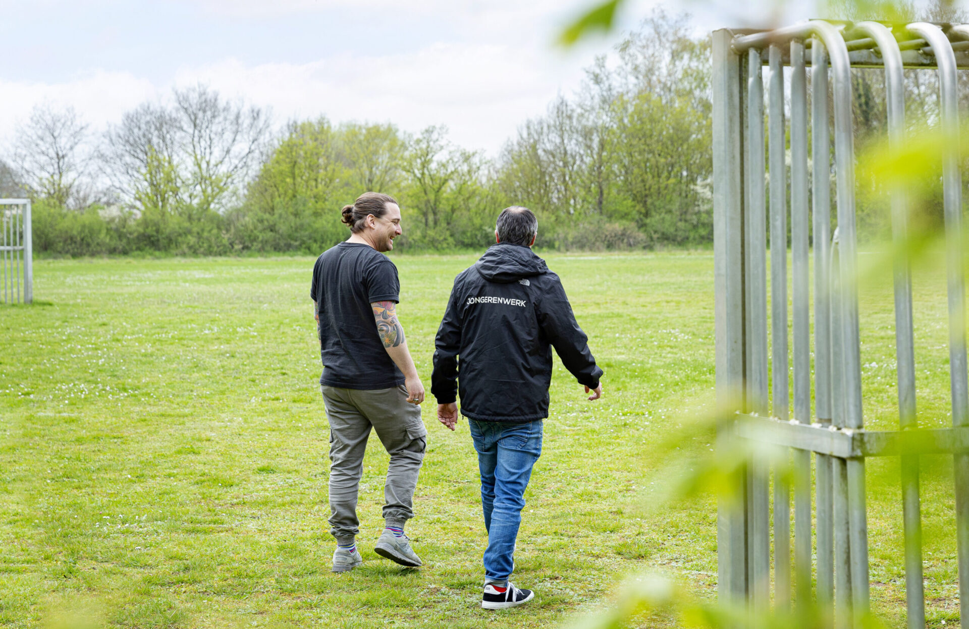 Foto jongerenwerker Synthese in gesprek met jongere op voetbalveldje