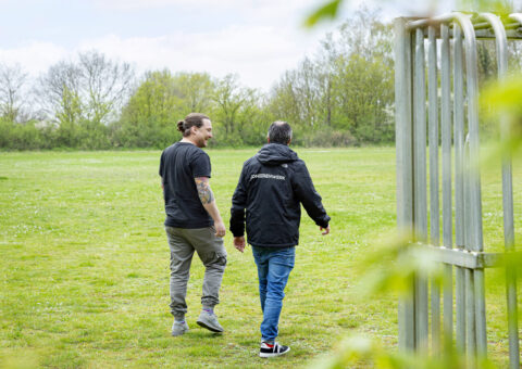 Foto jongerenwerker Synthese in gesprek met jongere op voetbalveldje