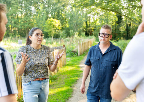 Opbouwwerkers in gesprek met inwoners bij de moestuin