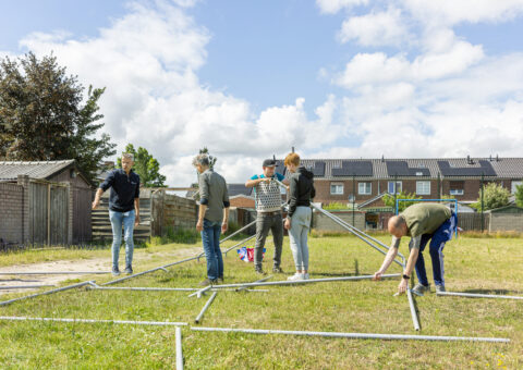 Foto inwoners bouwen samen een tent op