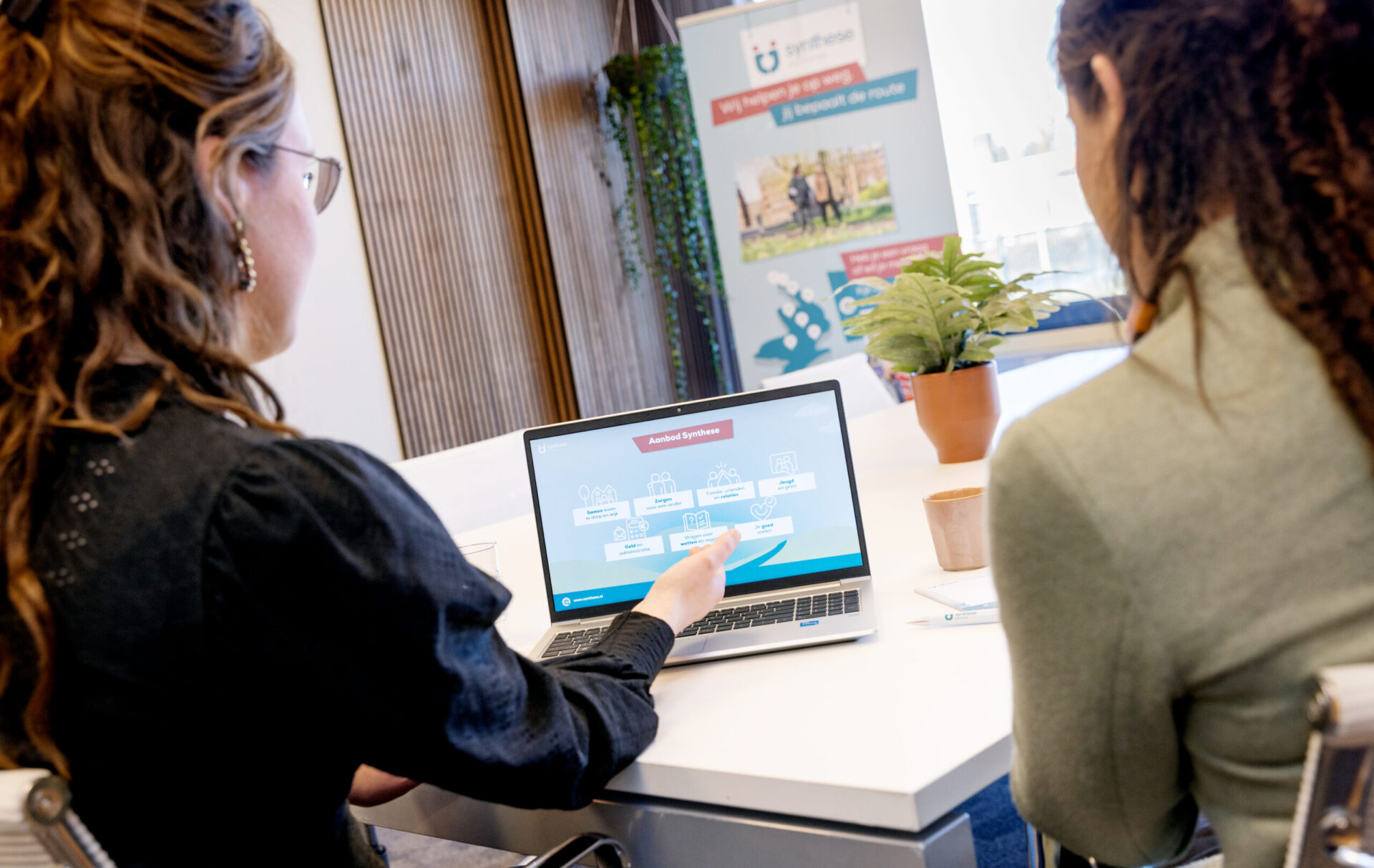 Medewerker Synthese in gesprek met inwoner over aanbod Synthese
